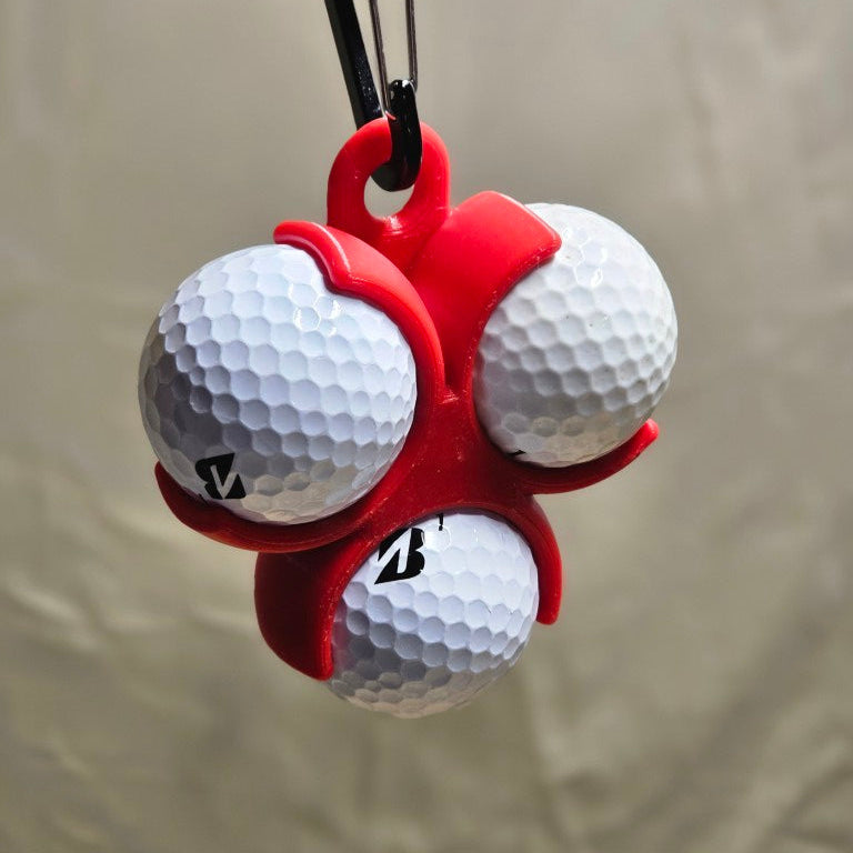 Red golf ball holder holding three golf balls on a beige background